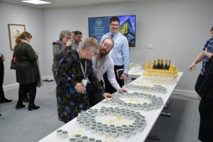 Staff members in the Wells Suite picking up centenary cupcakes