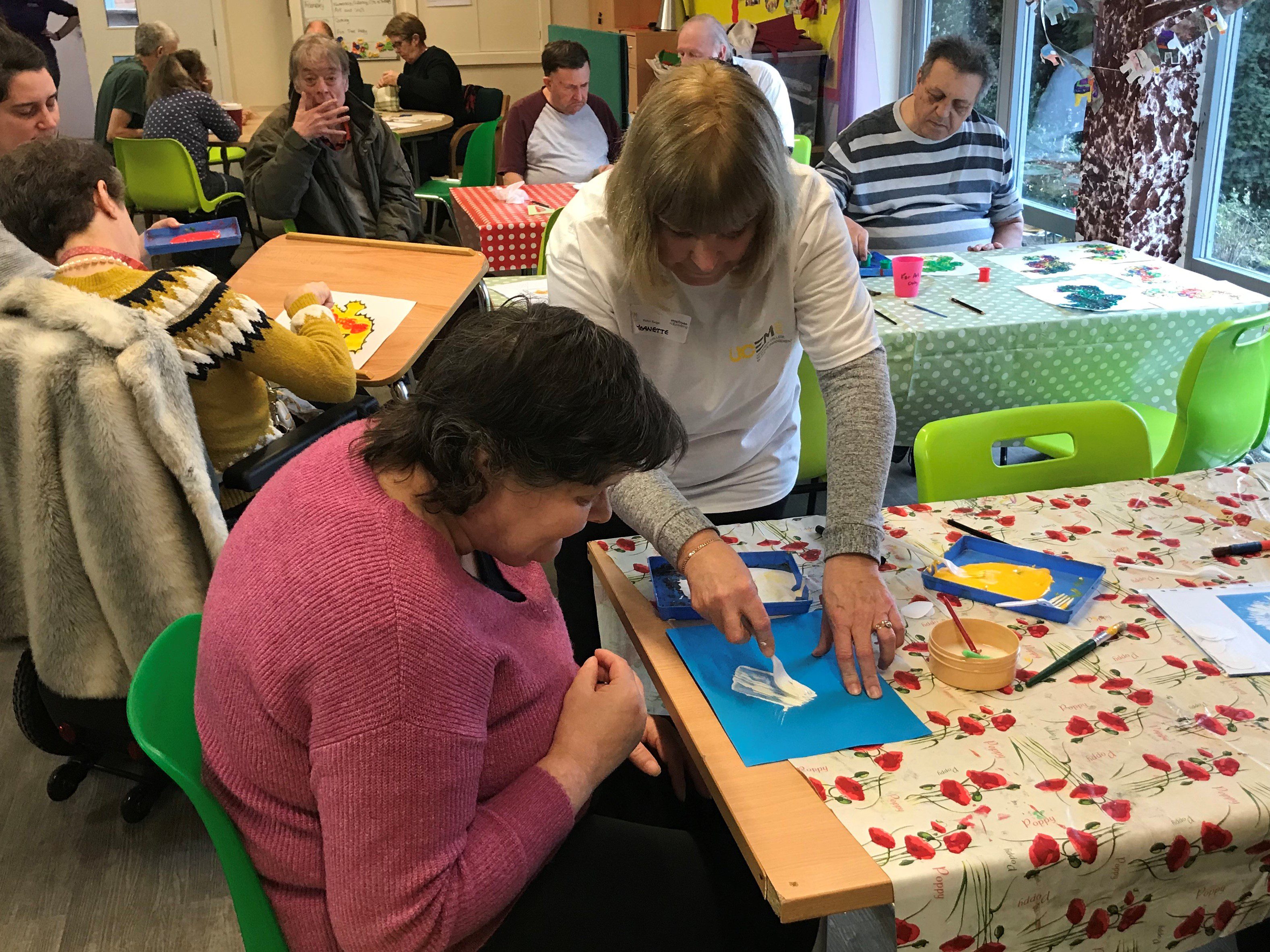 Member of staff putting glue on a piece of paper