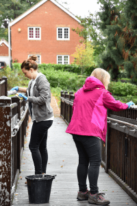 Volunteers scrubbing the handrails on the patio