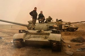 RICS CEO Justin Young crouching down on the tank. Photo supplied by Justin Young