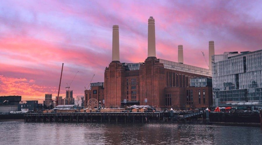 Dramatic sunset over Battersea Power Station in London, reflected on the River Thames.